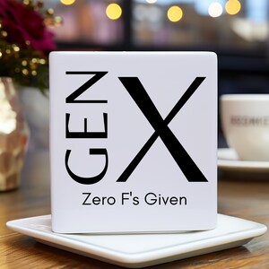 May include: White ceramic mug with black text that reads "GEN X Zero F's Given". The letter X is a large black graphic.
