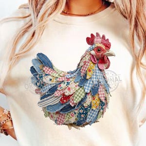 May include: A patchwork fabric chicken with a red comb, beak, and wattle. The chicken's body is made of various patterned fabrics, including denim, floral prints, and gingham. The chicken is on a white t-shirt.