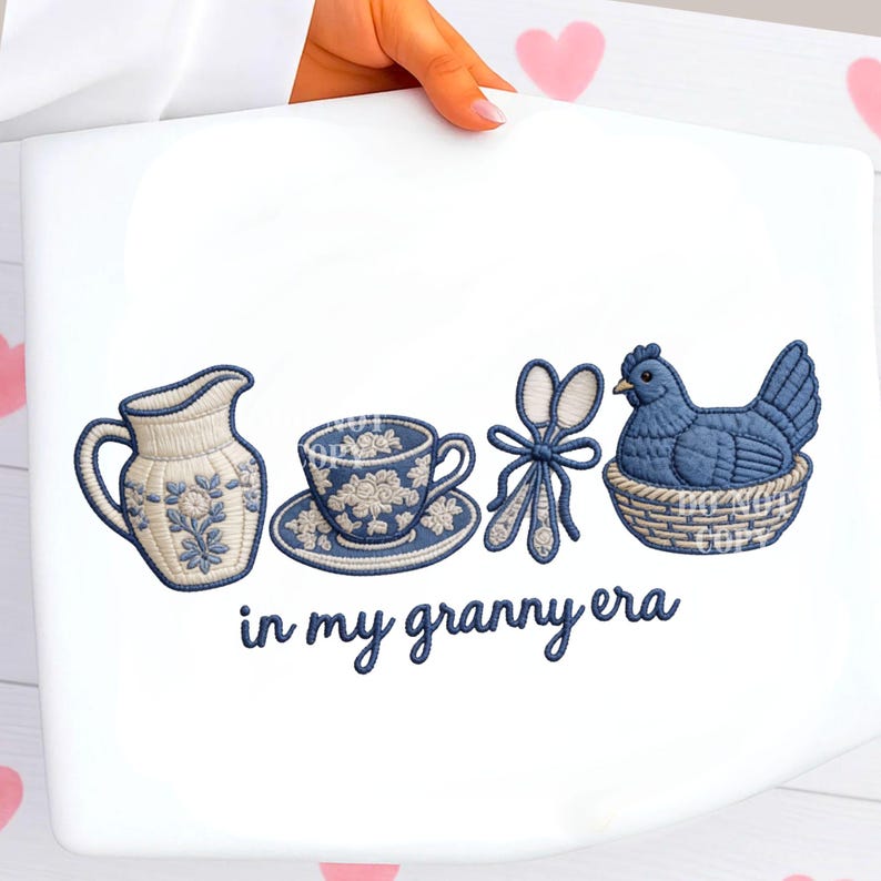 May include: White tote bag with embroidered blue and white images of a jug, teacup, scissors, and a hen in a basket. The text "in my granny era" is embroidered below the images.