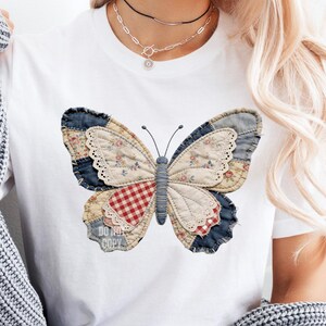 Pu&ograve; includere: T-shirt bianca con un grande disegno a farfalla. La farfalla &egrave; realizzata in tessuto patchwork con vari motivi, tra cui floreale, denim e quadretti. Il testo "DO NOT COPY" &egrave; visibile.