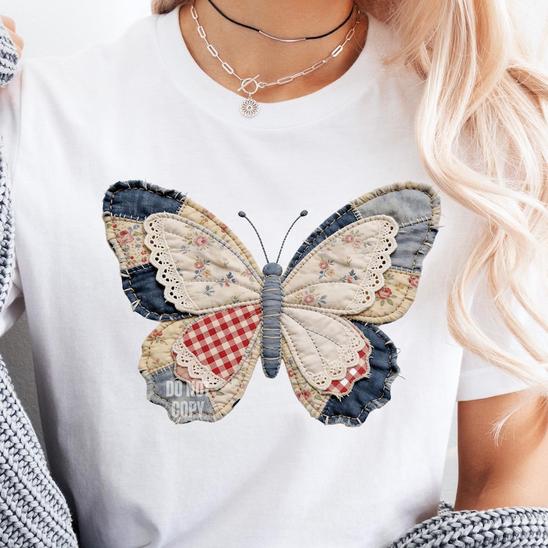 Pu&ograve; includere: T-shirt bianca con un grande disegno a farfalla. La farfalla &egrave; realizzata in tessuto patchwork con vari motivi, tra cui floreale, denim e quadretti. Il testo "DO NOT COPY" &egrave; visibile.