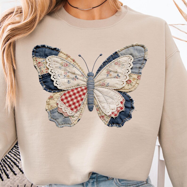 Pu&ograve; includere: Felpa beige con un grande disegno a farfalla. La farfalla &egrave; realizzata in tessuto patchwork con vari motivi, tra cui floreale, denim e scozzese rosso. La farfalla ha un corpo e antenne blu.