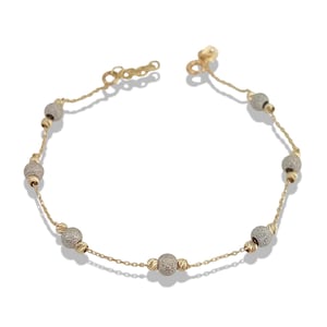 May include: A gold-toned bracelet featuring a delicate chain interspersed with textured, spherical beads. The bracelet has a lobster clasp closure and is displayed against a white background. The beads have a textured, glittery appearance.