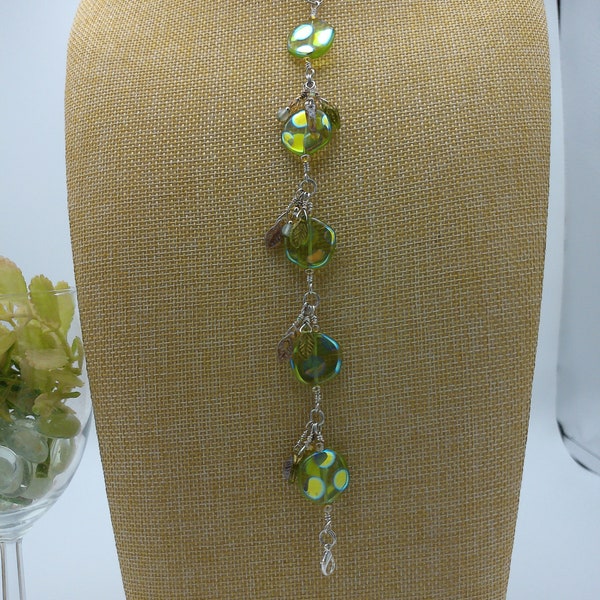 peridot green glass coin beaded bracelet with peacock finish dangling leaves and silver lobster claw clasp