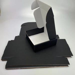 7 cajas de cartón corrugado de color negro (18 cm x 18 cm x 6,2 cm, negro/blanco) para envíos, cajas postales para paquetes pequeños, para negocios, almacenamiento o regalos.