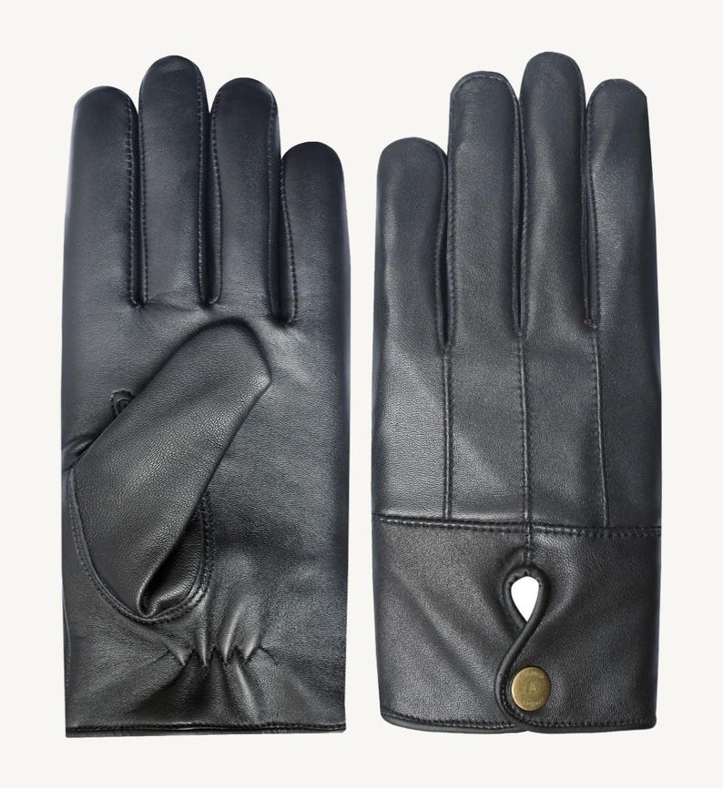 May include: A pair of black leather gloves with a button detail on the cuff.