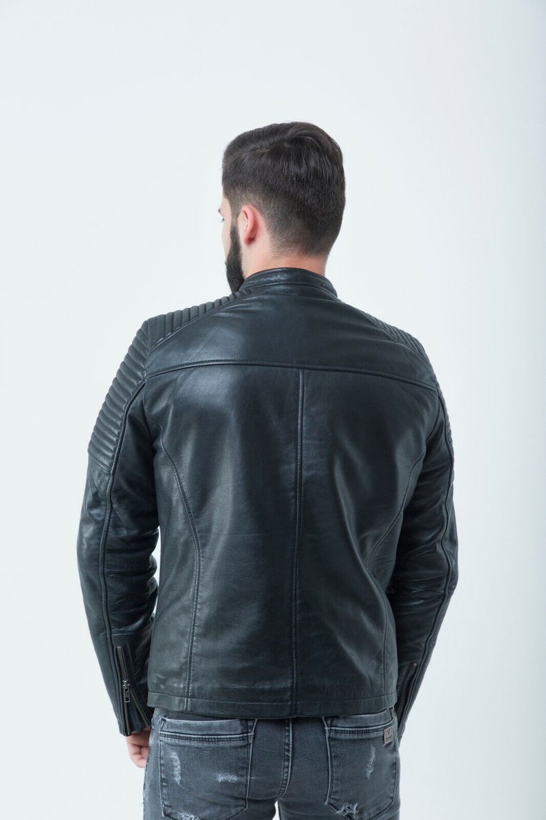Peut inclure: Une veste en cuir noire avec un design matelass&eacute; sur les &eacute;paules et les manches. La veste a une fermeture &eacute;clair et un col montant.