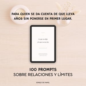 Puede incluir: Una tableta digital con marco negro muestra texto en español: "Lo que no digo y lo que no me doy." Debajo, el texto dice "100 PROMPTS SOBRE RELACIONES Y LÍMITES." La imagen incluye una vela blanca y un pequeño jarrón con flores secas.