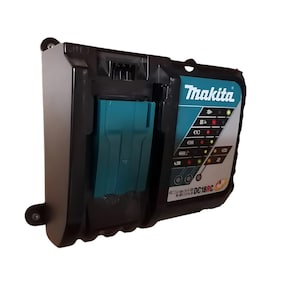 Op de afbeelding: Een zwarte Makita DC18RC lader met een groen-zwarte batterij erin. De lader heeft een reeks lampjes die de laadstatus aangeven.