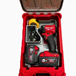 Peut inclure: Un kit de visseuse à percussion Milwaukee rouge et noir. Le kit comprend une perceuse, deux batteries, un mètre ruban et divers embouts de vissage. Le kit est logé dans un boîtier en plastique rouge avec un couvercle transparent.