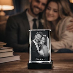 May include: A rectangular glass block featuring a laser-etched black and white photograph of a couple in formal attire. The glass sits on a black base and includes the engraved text I Love You at the bottom of the image within the glass.