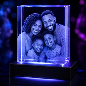 May include: A rectangular glass block featuring a laser-etched 3D portrait of a family of four, including two adults and two children, illuminated by a blue light base. The clear crystal block displays the detailed faces and upper bodies of the family.