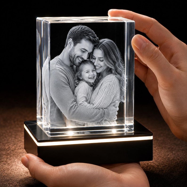 May include: A rectangular glass block featuring a laser-etched 3D monochrome photograph of a family of three, including a man, a woman, and a young child. The glass block sits on a black rectangular base with an integrated light strip.