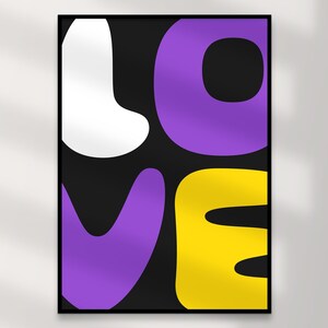 May include: A framed art print featuring the word "LOVE" in bold, rounded letters. The letters are in white, purple, and yellow against a black background. The artwork has a modern, graphic design aesthetic.