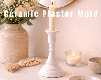 May include: A white ceramic candlestick holds a lit candle, with a second candle burning in a glass votive. The image also features a vase of flowers, a decorative beaded tassel, and small bowls. Text on the image reads "Ceramic Plaster Mold."