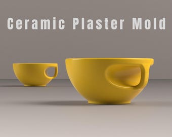 May include: Two yellow ceramic plaster molds. The larger bowl-shaped mold has a curved handle. The smaller mold is in the background. The text "Ceramic Plaster Mold" is at the top of the image.