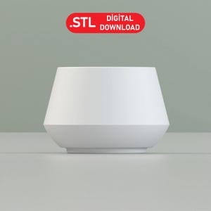 May include: White ceramic planter with a wide, rounded base and a slightly flared top.  The planter is designed for indoor plants and has a modern, minimalist style.