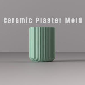 Op de afbeelding: Een lichtgroene keramische gipsmal met verticale geribbelde details. De mal is cilindrisch met een afgeronde basis. De tekst "Ceramic Plaster Mold" wordt in het wit weergegeven.