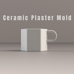 May include: A white ceramic mug with a geometric design and a handle. The mug is labelled "Ceramic Plaster Mold" in white text. The mug is set against a neutral background.