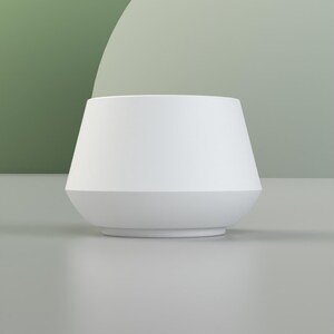 May include: A white ceramic planter with a wide, rounded base and a slightly flared top.