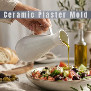 Könnte beinhalten: Ein weißer Keramikkrug gießt Olivenöl über einen frischen Salat mit Tomaten, Gurken, Oliven und Feta-Käse. Das Bild enthält eine Flasche Olivenöl und eine Schüssel mit Oliven. Der Text auf dem Bild lautet "Ceramic Plaster Mold."