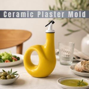 Peut inclure: Un distributeur d'huile en céramique jaune vif avec un corps en forme de beignet et un bec verseur blanc. Le texte "Ceramic Plaster Mold" est visible en haut de l'image. Le distributeur présente une finition lisse et brillante.