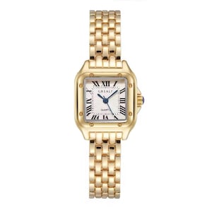 May include: A gold-tone watch with a square case and a matching link bracelet. The white dial features black Roman numeral hour markers, the text GREALY and QUARTZ, and blue hands. A small blue stone is set into the side winding crown.