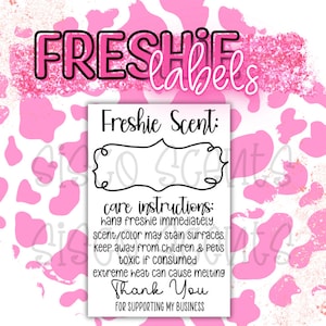 Op de afbeelding: Een witte kaart met zwarte tekst op een roze en witte achtergrond. De kaart zegt "Freshie Scent:" en heeft instructies voor het verzorgen van een freshie. De instructies zeggen om de freshie onmiddellijk op te hangen, hem uit de buurt van kinderen en huisdieren te houden en dat extreme hitte kan leiden tot smelten. De kaart zegt ook "Bedankt voor het steunen van mijn bedrijf."