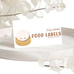Puede incluir: Etiquetas de alimentos imprimibles con una linda ilustración de dibujos animados de un pan al vapor con una cara sonriente. El texto "Totalmente editable FOOD LABELS agrega tu propio texto" se muestra en la etiqueta.