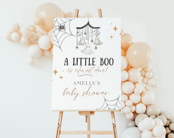 Puede incluir: Un cartel blanco con una ilustración en blanco y negro de un móvil de fantasmas con el texto "A Little Boo is almost due! Welcome to Amelia's Baby Shower".