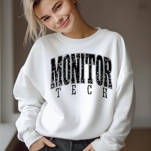May include: White sweatshirt with black text that reads "MONITOR TECH" in a distressed font.