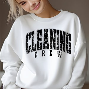May include: White sweatshirt with a black distressed graphic that reads "Cleaning Crew".