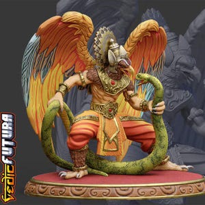 May include: A detailed figurine of a winged humanoid figure with a bird-like head, wearing ornate gold armour and orange garments, holding a large green snake. The figure stands on a circular base with a red top and gold trim, featuring the text VEDIC FUTURA.