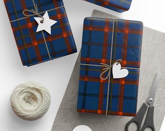 Puede incluir: Vista aérea de regalos envueltos en papel a cuadros azul, naranja y marrón. Cada regalo está atado con hilo y una etiqueta blanca en forma de estrella o corazón. También hay una madeja de hilo, tijeras y etiquetas en blanco.