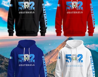 May include: Four hooded sweatshirts in different colors: black, red, blue, and white. Each sweatshirt features a graphic design with the number "502" and the word "GUATEMALA" printed on the front. The number "502" is stylized to look like a cityscape, and the word "GUATEMALA" is printed below the number. The sweatshirts also have the word "GUATEMALA" printed down the left sleeve.