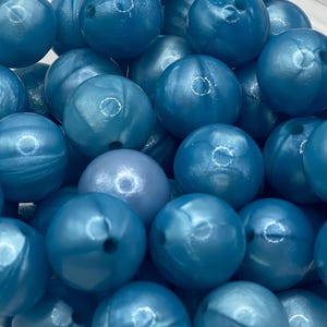 May include: A collection of blue, iridescent, round silicone beads. The beads have a smooth, glossy finish and are perfect for making jewelry or other crafts.