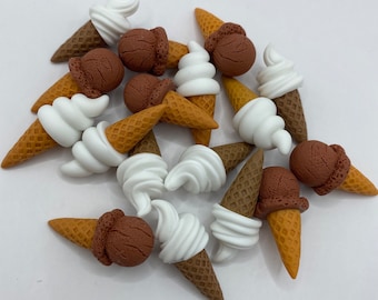 May include: A collection of miniature ice cream cones made of polymer clay. The cones are brown and white with brown and white ice cream scoops.