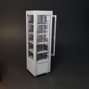 Puede incluir: Una vitrina de exposición de puerta de vidrio gris con cinco estantes. La vitrina tiene un marco de metal y una base blanca con un diseño de listones.