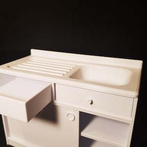 May include: White miniature kitchen sink with a drainer, a drawer, and a shelf. The sink is made of plastic and has a white finish.