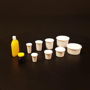 May include: A set of miniature white plastic cups and bowls, a small yellow and black jar, and a small orange bottle.