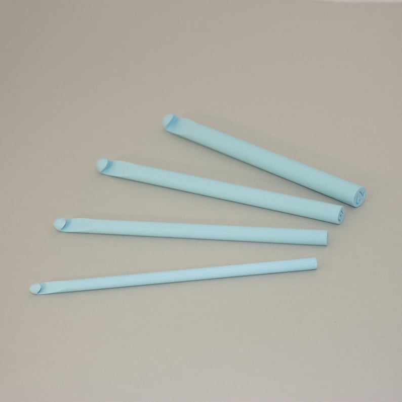 May include: Four light blue crochet hooks of different sizes.