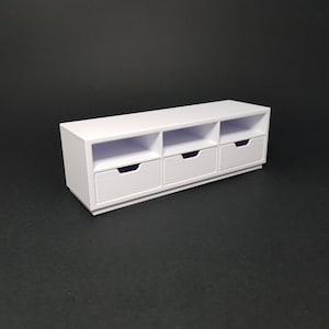 May include: White media console with three drawers and three open shelves. The console is made of wood and has a modern design.