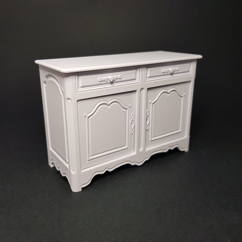 May include: A white painted wooden cabinet with two drawers and two doors. The cabinet has ornate carvings and a curved base.