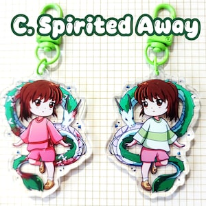 May include: Two acrylic keychains featuring a cartoon character from "Spirited Away." Each keychain shows a girl in pink or green clothing with a green and white dragon. The keychains have green clasps and the text "C. Spirited Away."
