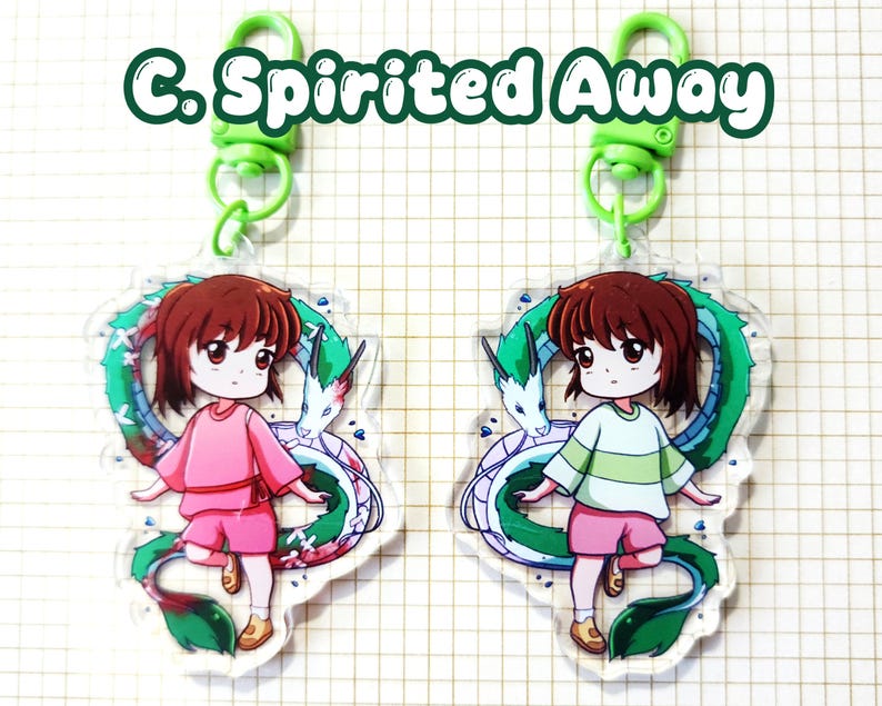 May include: Two acrylic keychains featuring a cartoon character from "Spirited Away." Each keychain shows a girl in pink or green clothing with a green and white dragon. The keychains have green clasps and the text "C. Spirited Away."