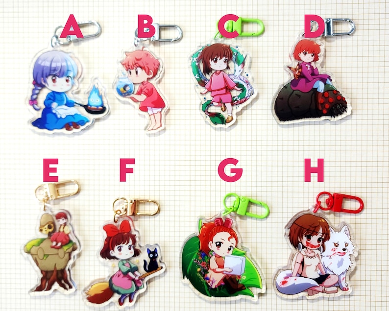 May include: A collection of eight acrylic keychains featuring anime-style characters. Each keychain has a different character design, with various colors and poses. The keychains have metal clasps for attachment.