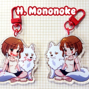 May include: Two clear acrylic keychains featuring a cartoon girl with brown hair and a white wolf. The girl has red accents on her face and is wearing a white top and black skirt. The keychains have red clasps and the text "H. Mononoke" in red.
