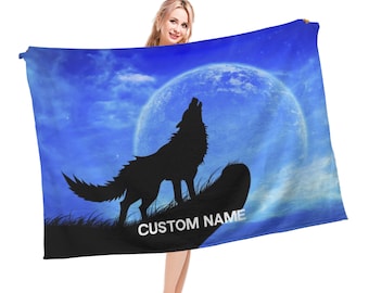Puede incluir: Una toalla de playa azul y blanca con la silueta de un lobo aullando a la luna. La toalla tiene el texto "CUSTOM NAME" impreso.