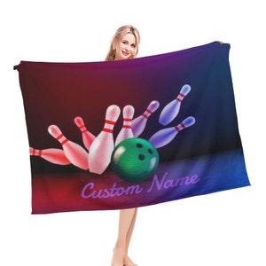 May include: A purple, blue, and red fleece blanket with a bowling ball and pins graphic. The text "Custom Name" is printed on the blanket.