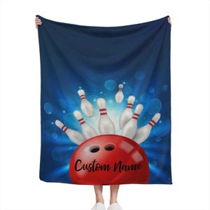 May include: A red bowling ball with a blue background and white bowling pins. The bowling ball has the text "Custom Name" on it.